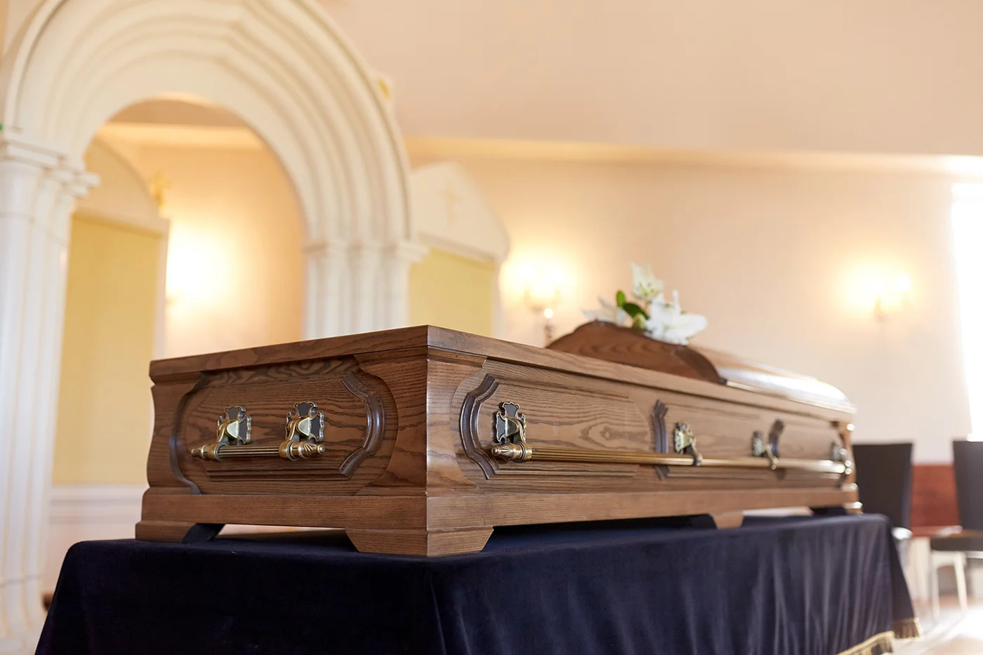 Casket and floral arrangement in a chapel, from the original Jackson and Highley website