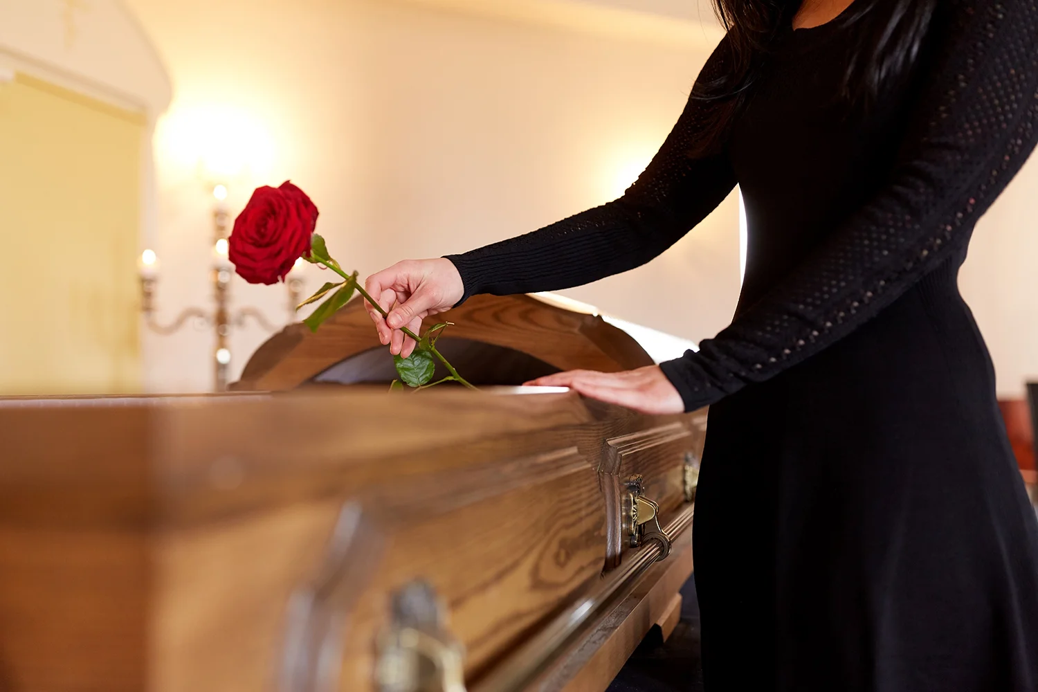 A rose placed beside a casket in a personal farewell